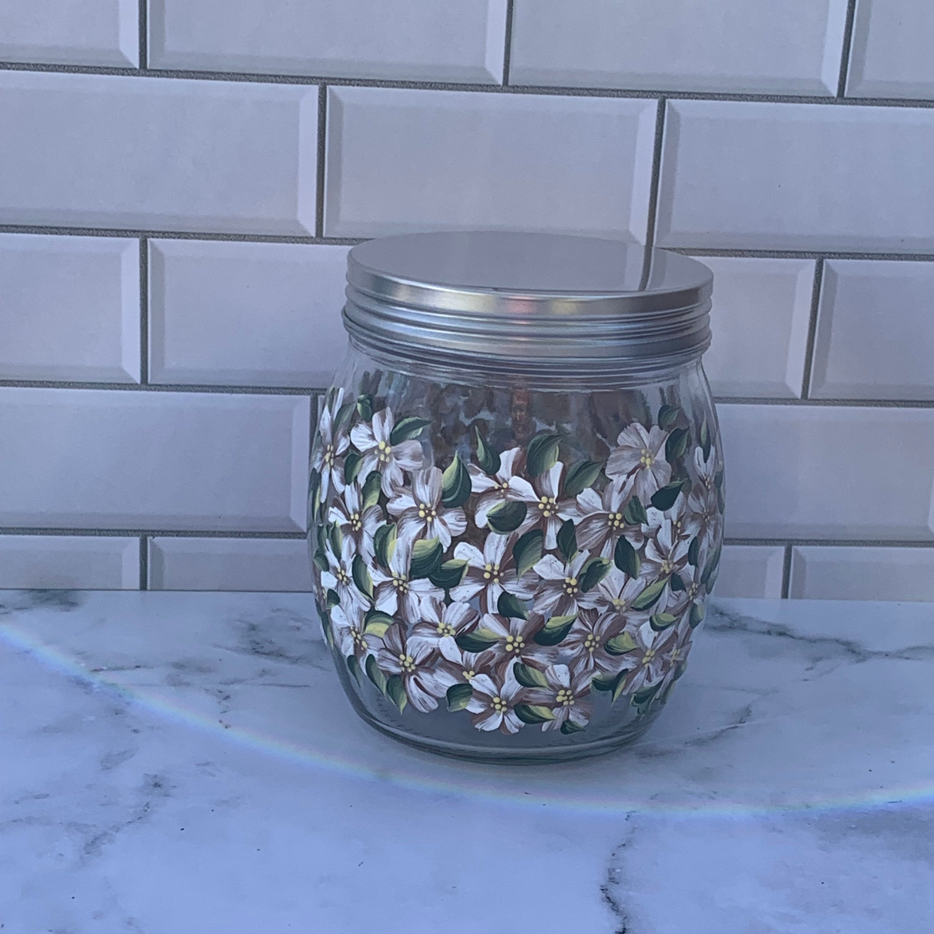 27 oz round glass storage jar with metal screw on lid hand painted with off-white hydrangeas all around